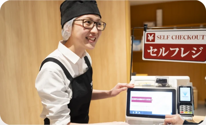セルフレジの使い方を案内するスタッフ